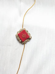 Red kasuti rakhi with intricate hand embroidery design